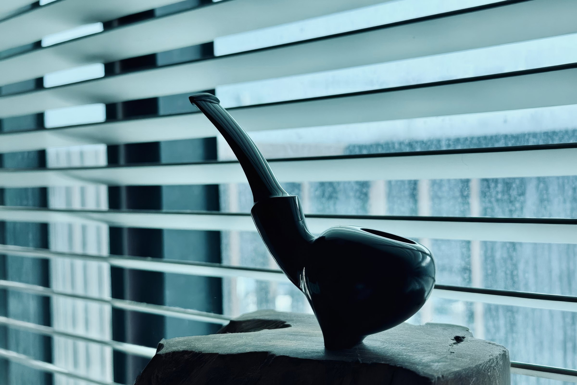 Black sculptural pipe — stand view